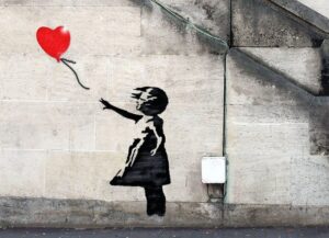 murales di banksy bambina con palloncino rosso a forma di cuore che vola via
